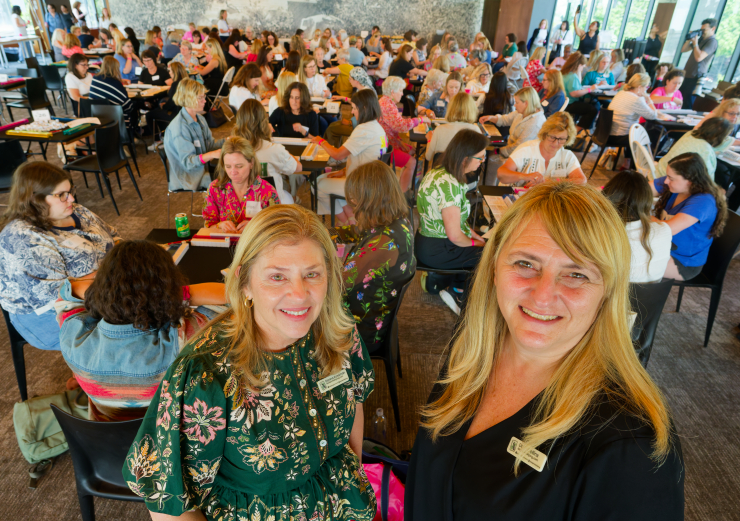 Donna Kassman, left, and Dara Collins, the festival’s two main organizers, are superstars in the mahjong world, with nearly 25,000 Instagram followers. Behind them is one of two major tournaments being held in the museum events hall. Photo: Carl Glassman/Tribeca Trib