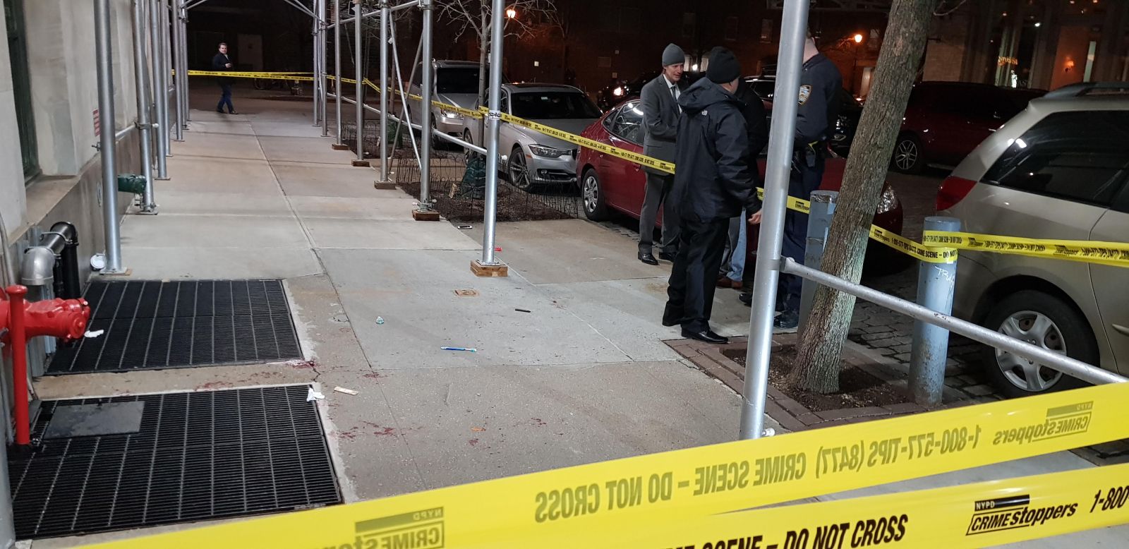 Detectives investigate a stabbing Saturday night near the corner of Jay and Greenwich Streets. Blood stained the sidewalk close to the Jay Street entrance to 335 Greenwich Street. Photo: Allan Tannenbaum